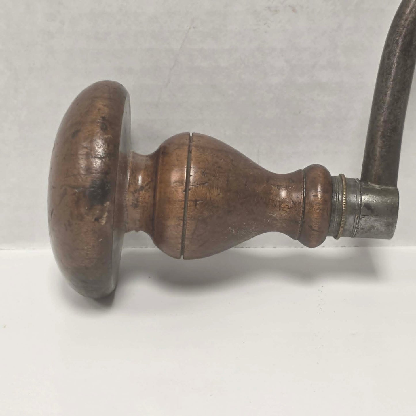 An exquisitely crafted antique walnut-handled bit brace that showcases the beauty and precision of early woodworking tools.

