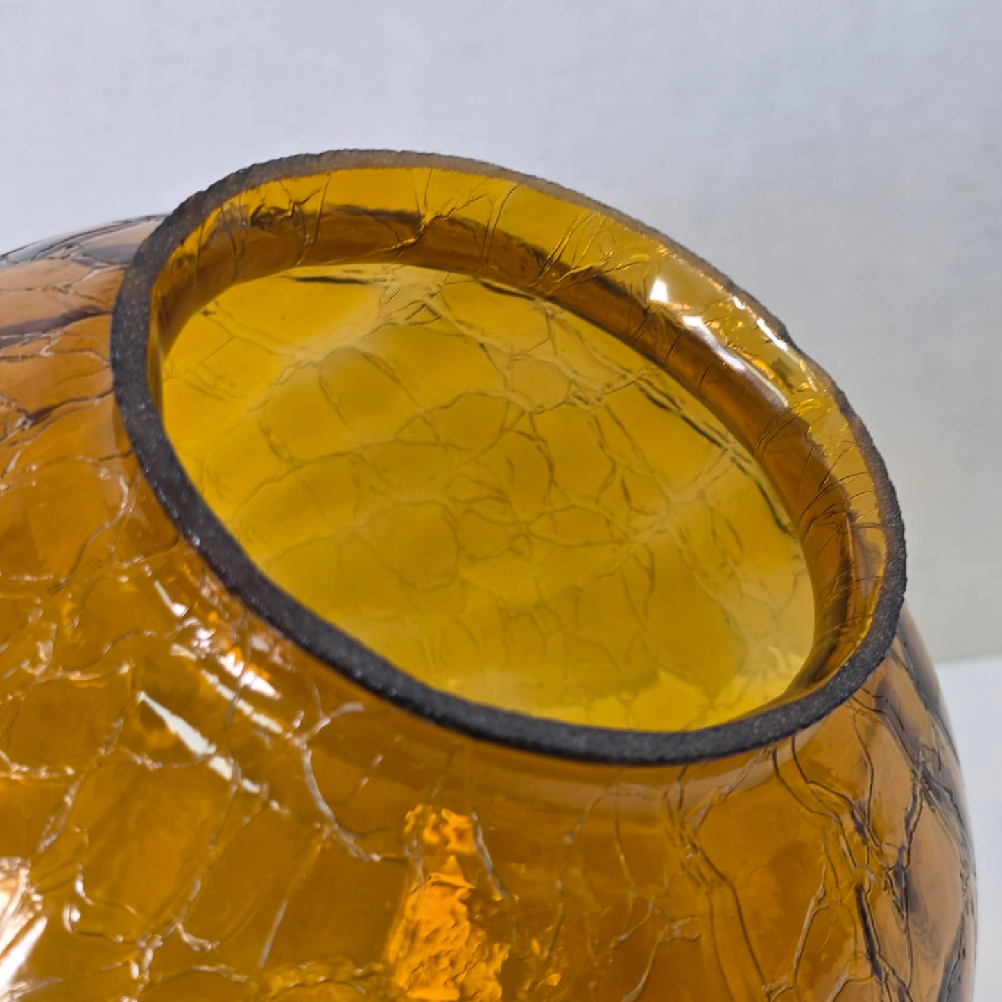 Vintage amber glass crinkle lamp globe casting a warm, patterned glow.