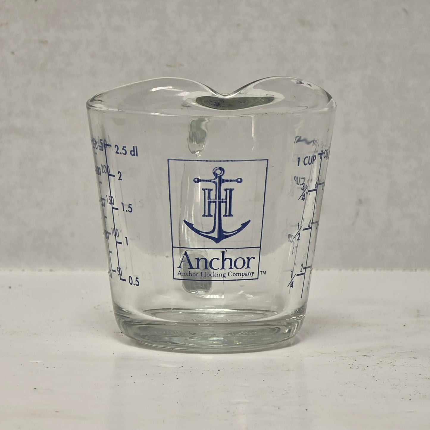 Vintage Anchor Hocking glass measuring cup with Imperial and metric measurements.
