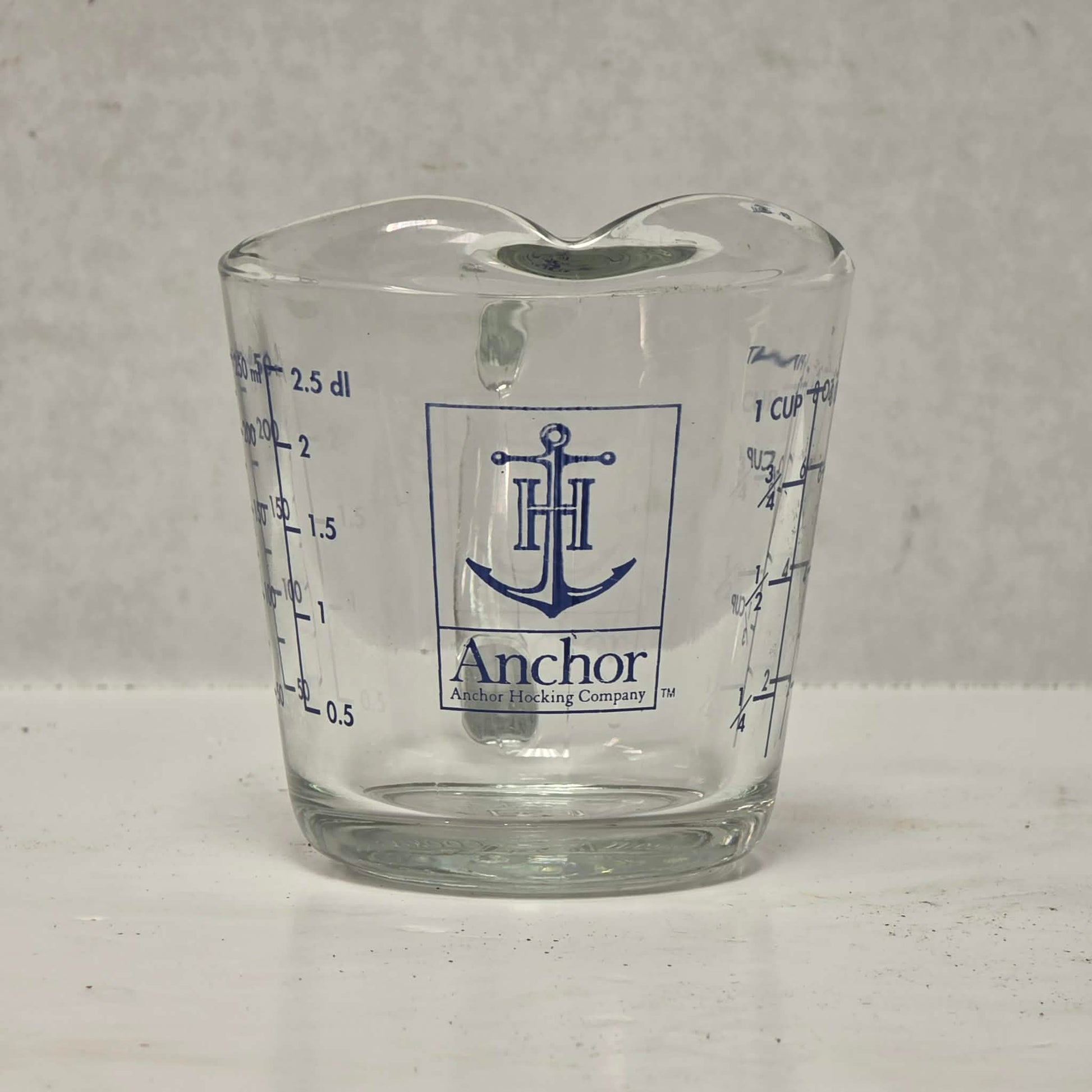 Vintage Anchor Hocking glass measuring cup with Imperial and metric measurements.
