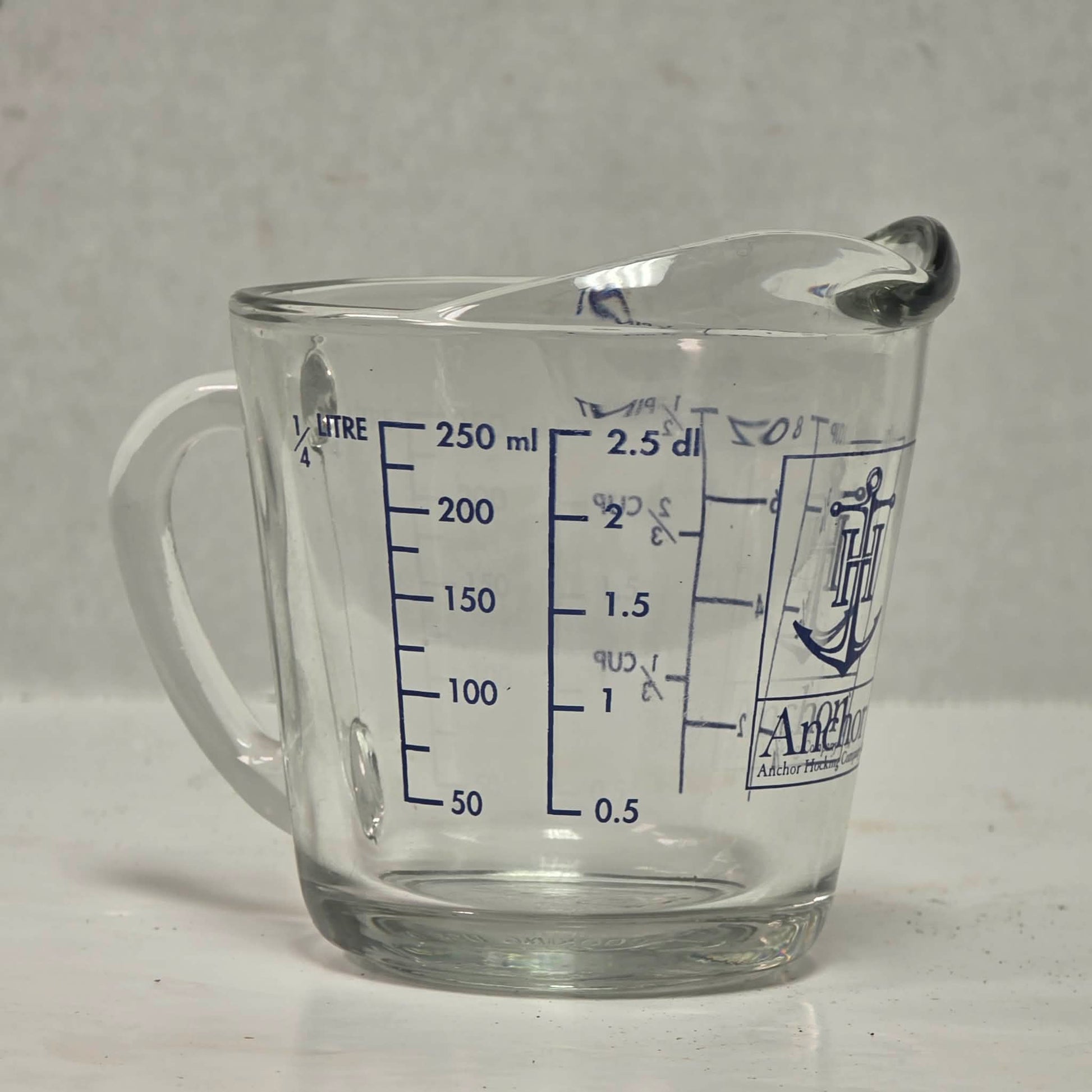 Vintage Anchor Hocking glass measuring cup with Imperial and metric measurements.
