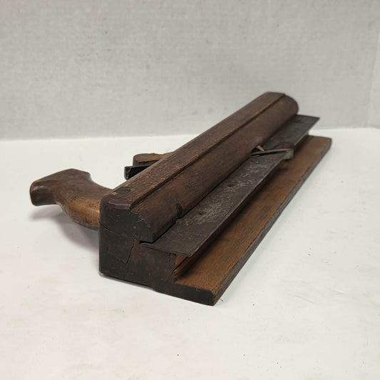 Antique wooden grooving plane with steel rail for tongue and groove woodworking.
