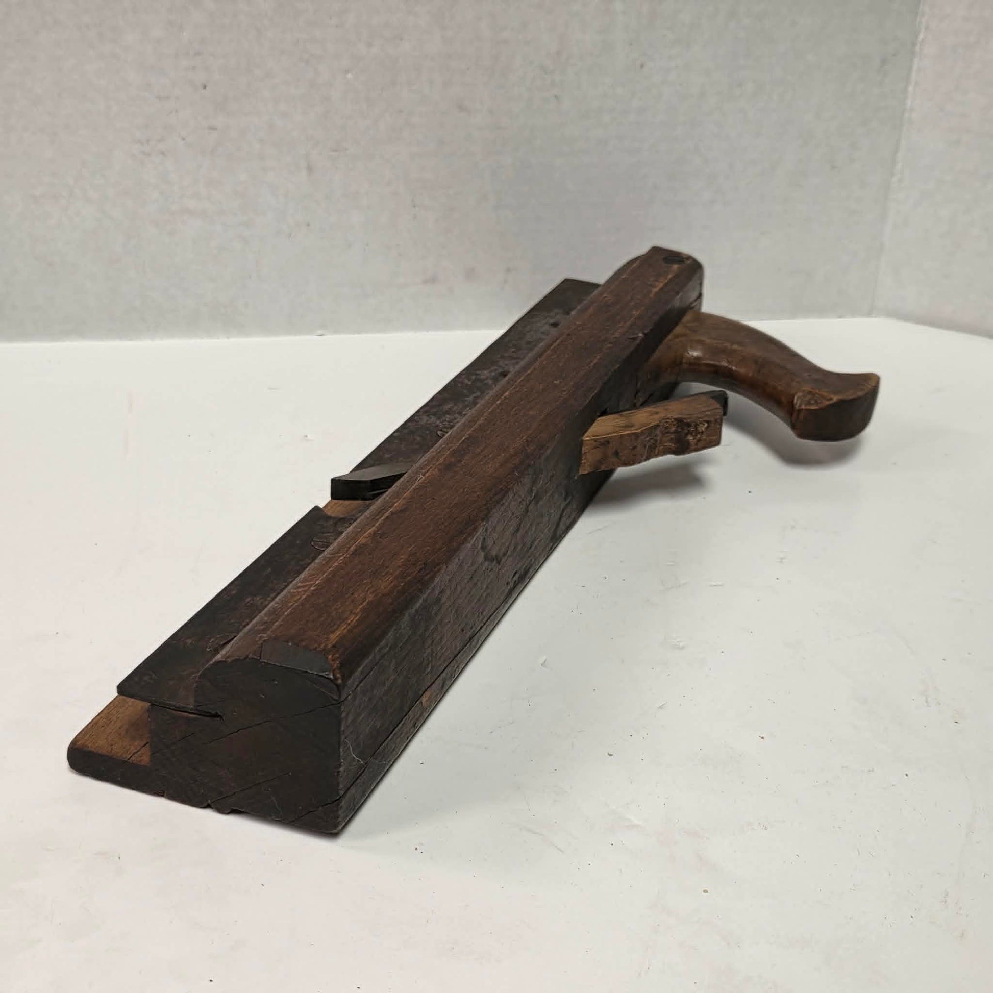 Antique wooden grooving plane with steel rail for tongue and groove woodworking.
