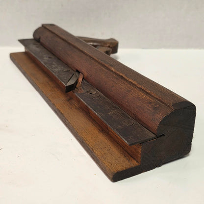 Antique wooden grooving plane with steel rail for tongue and groove woodworking.
