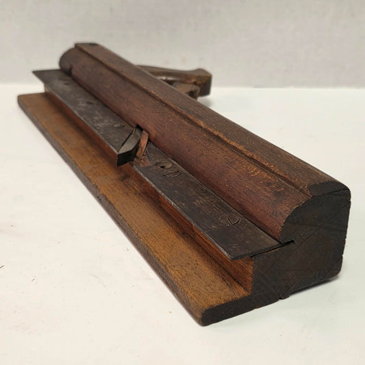 Antique wooden grooving plane with steel rail for tongue and groove woodworking.
