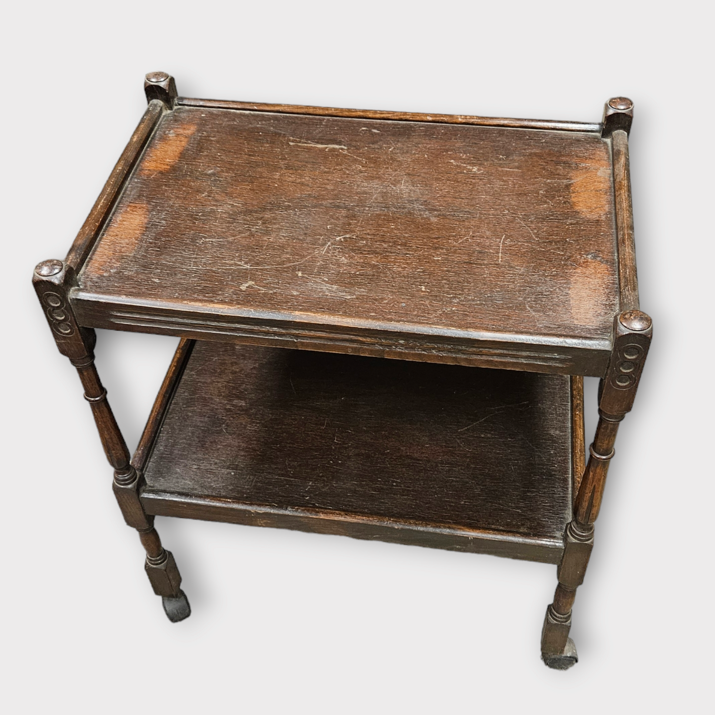 Antique wooden rolling serving table with a rectangular top and a lower shelf, featuring curved legs and a flat surface.