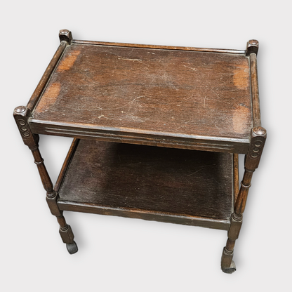 Antique wooden rolling serving table with a rectangular top and a lower shelf, featuring curved legs and a flat surface.