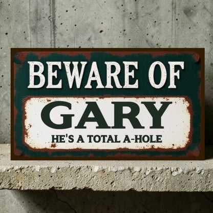 Sign with text 'Beware of Gary He's a total a-hole' on a concrete wall.