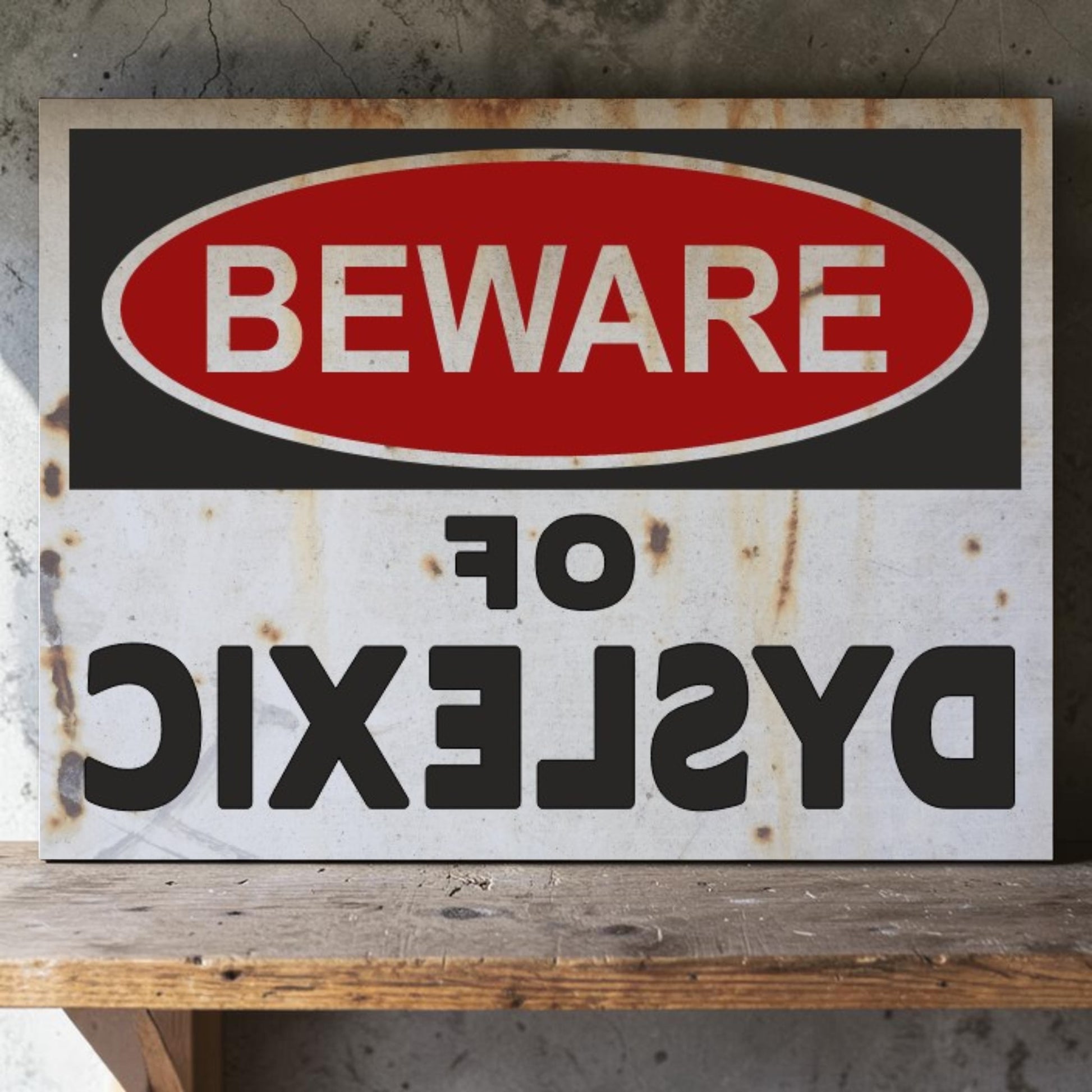 Rustic metal sign with 'Beware of Dyslexic' text on a wooden surface.