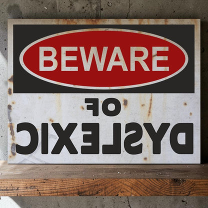 Rustic warning sign with 'Beware of Dyslexic' text on a wooden surface.