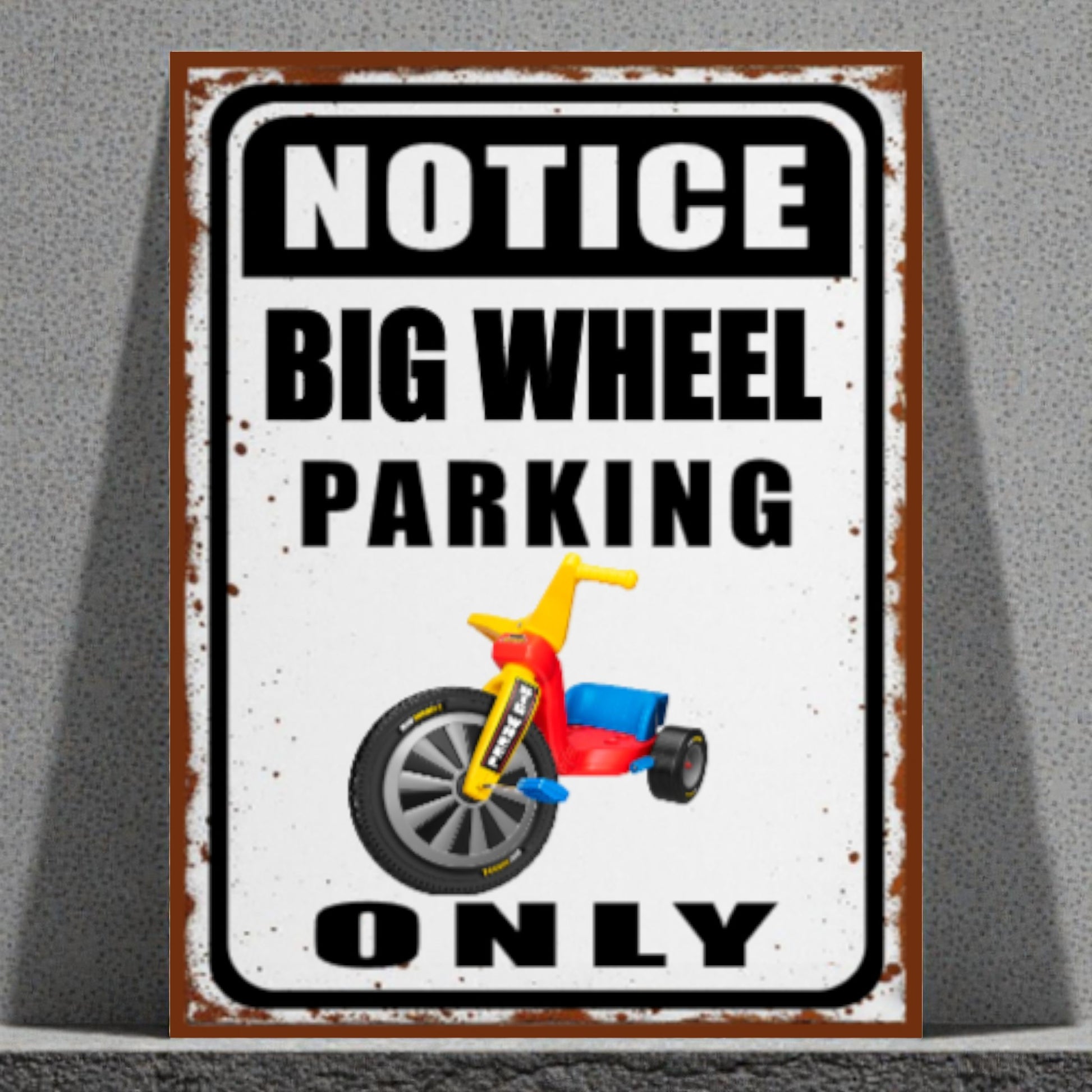 Metal sign with a tricycle graphic and text 'Notice Big Wheel Parking Only' on a gray background