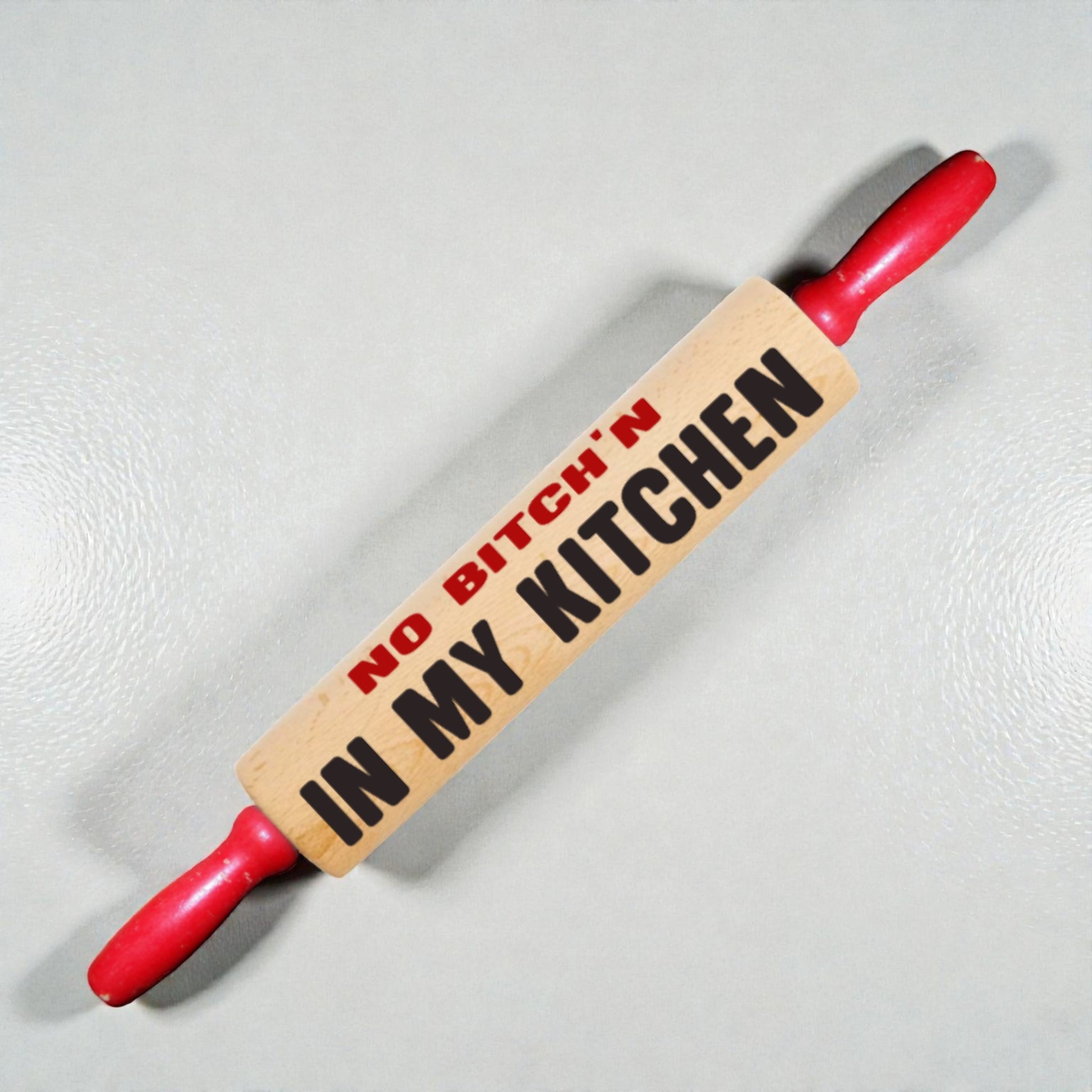 Rolling pin with 'No Bitch'n in My Kitchen' text on a light background