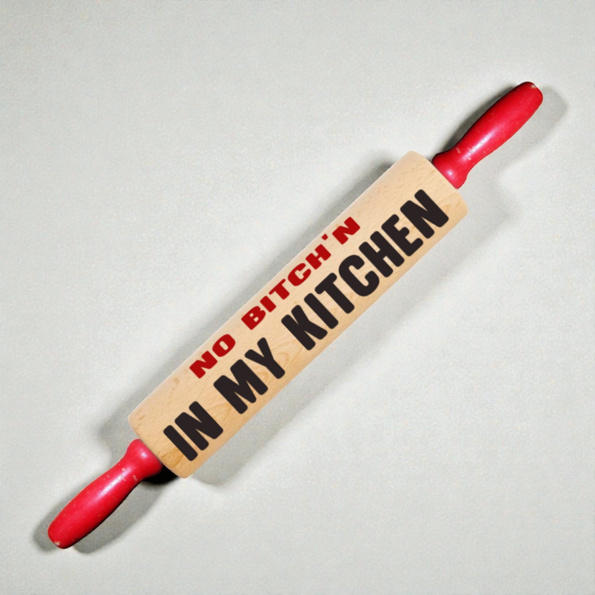 Rolling pin with 'No Bitch'n in My Kitchen' text on a light background