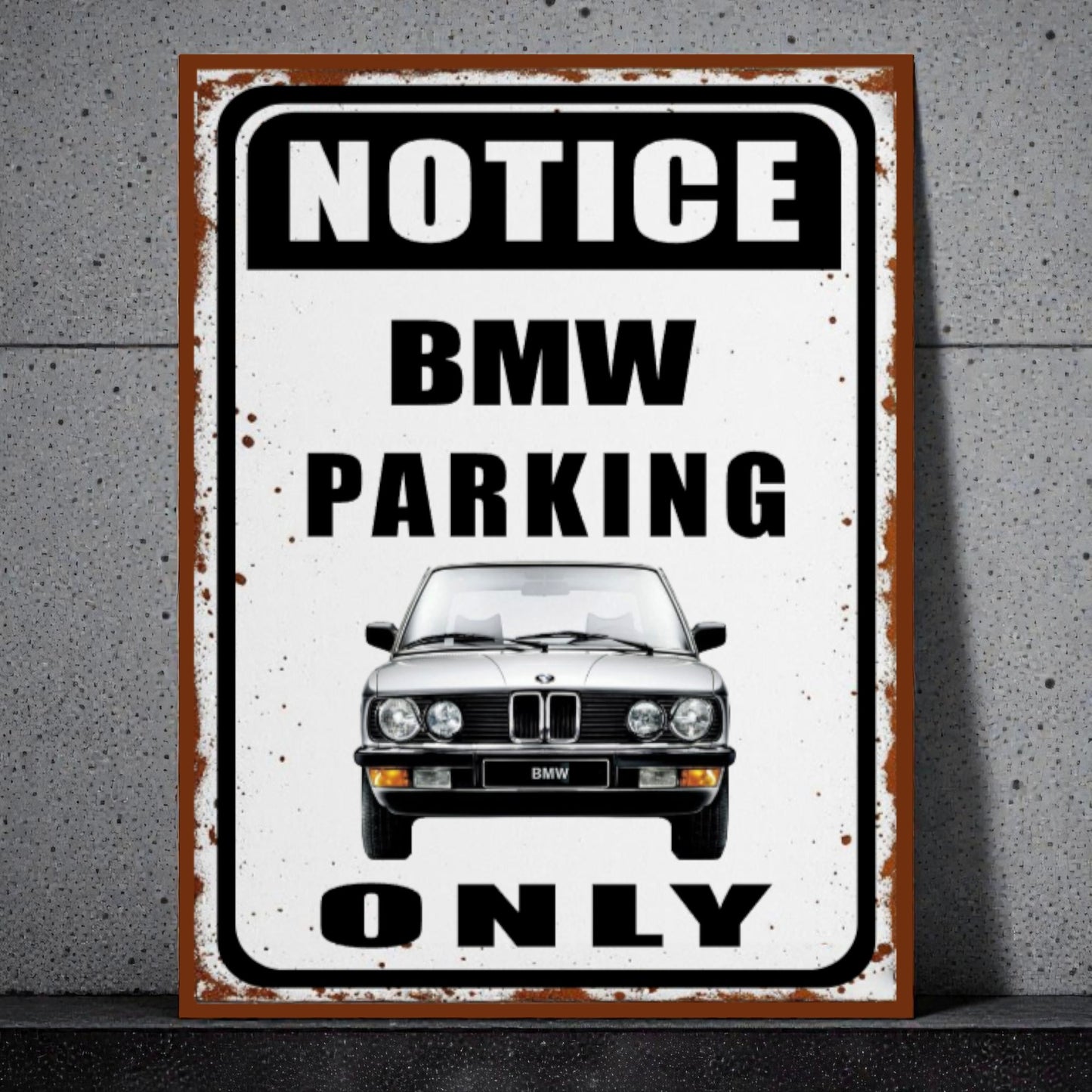 Vintage-style metal sign with BMW logo and text 'Notice BMW Parking Only' on a concrete wall.