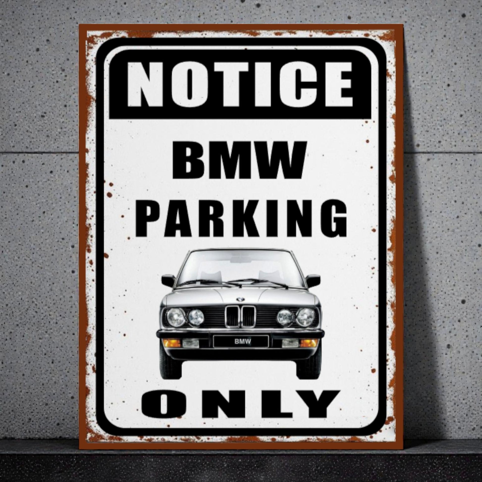 Vintage-style metal sign with BMW logo and text 'Notice BMW Parking Only' on a concrete wall.