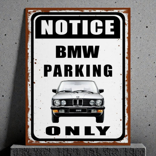 Vintage-style metal sign with BMW logo and text 'Notice BMW Parking Only' on a gray background.
