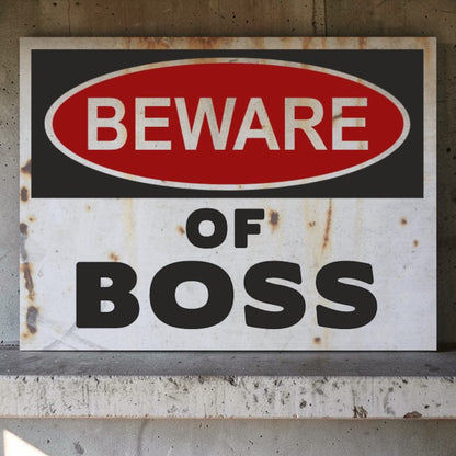 Rustic warning sign with 'Beware of Boss' text on a concrete surface