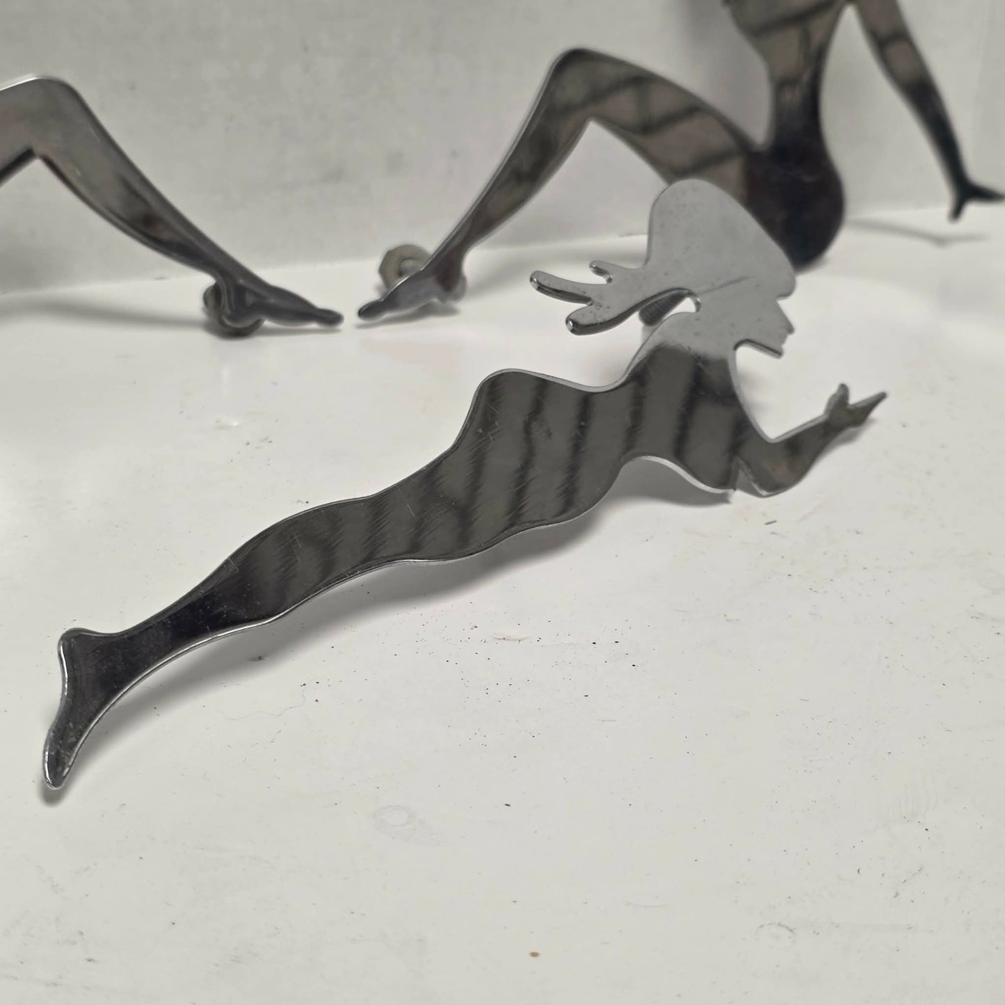 Set of three stainless steel vintage trucker mud flap girl decorations.

