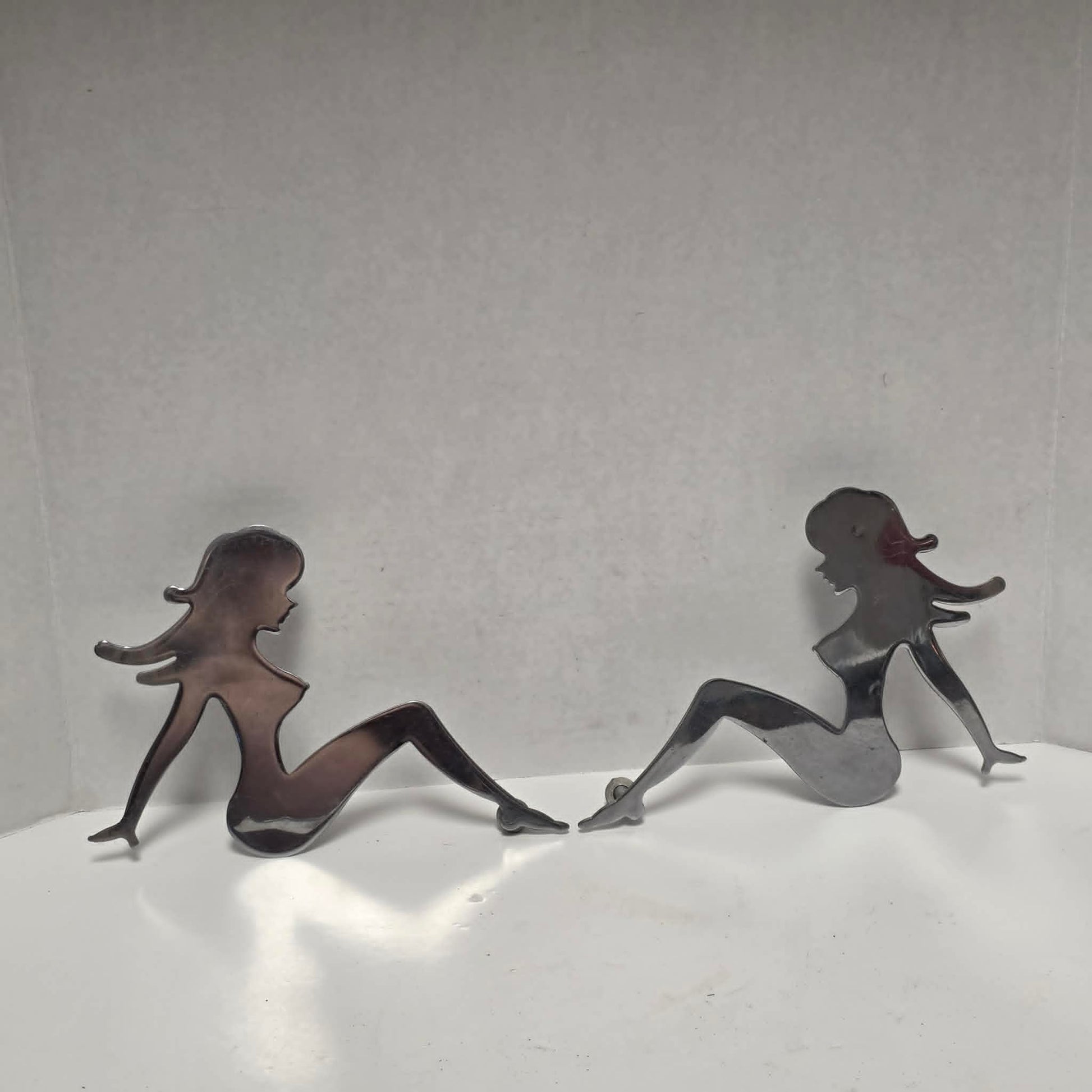 Set of three stainless steel vintage trucker mud flap girl decorations.
