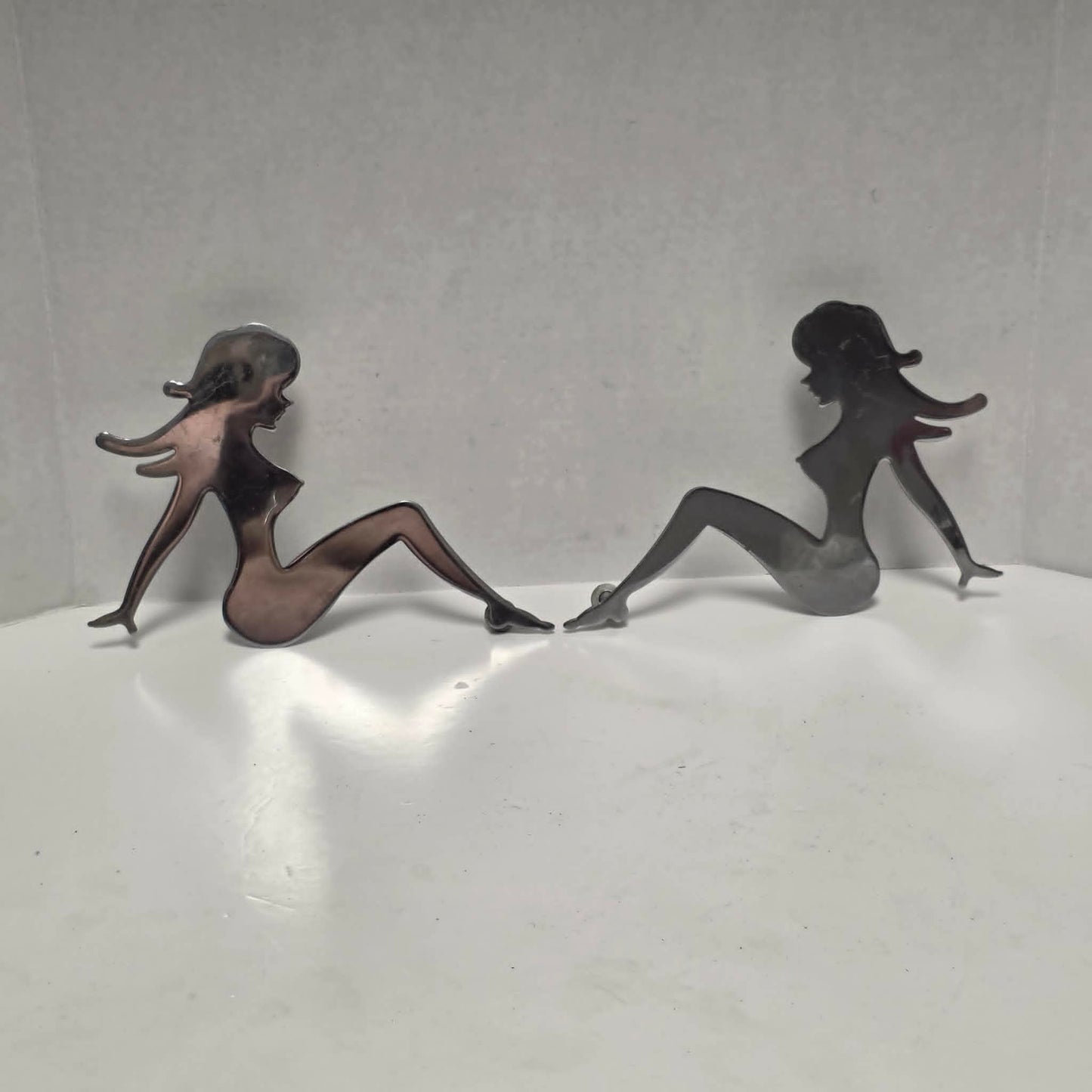 Set of three stainless steel vintage trucker mud flap girl decorations.
