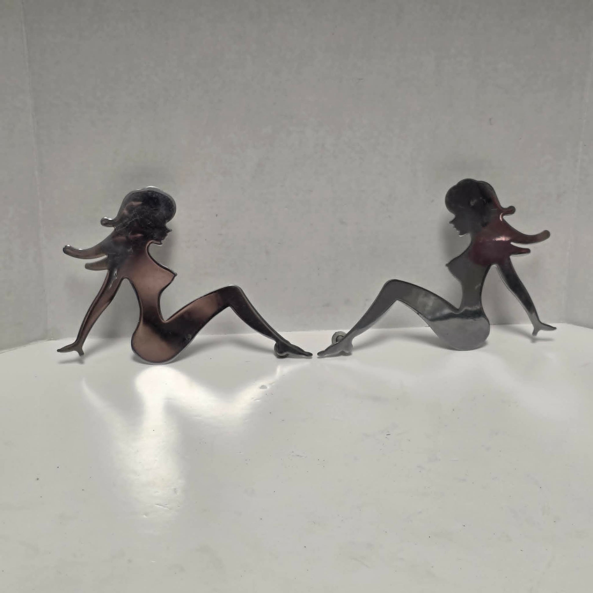 Set of three stainless steel vintage trucker mud flap girl decorations.
