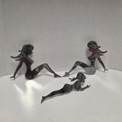 Set of three stainless steel vintage trucker mud flap girl decorations.
