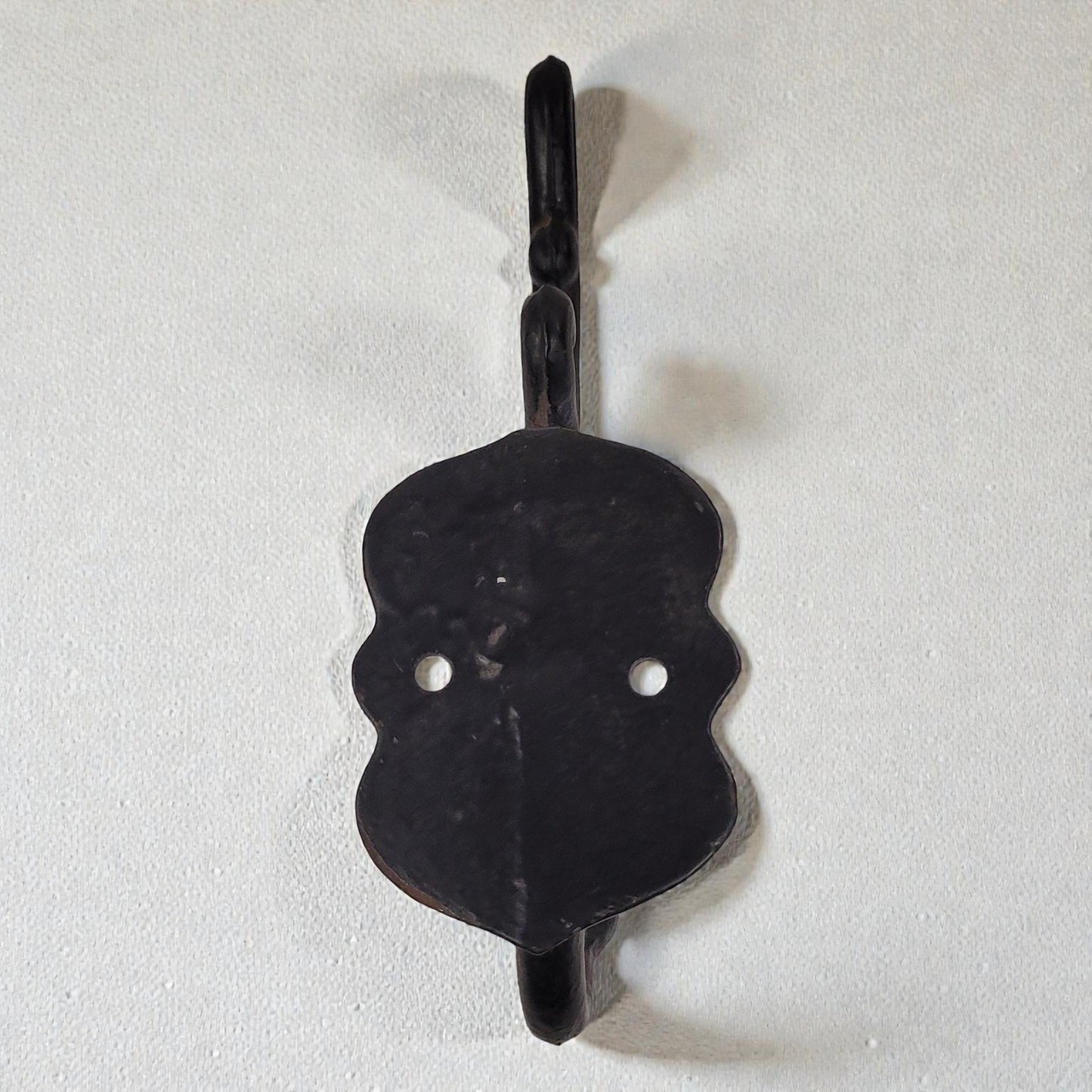 Black metal hook on a white background