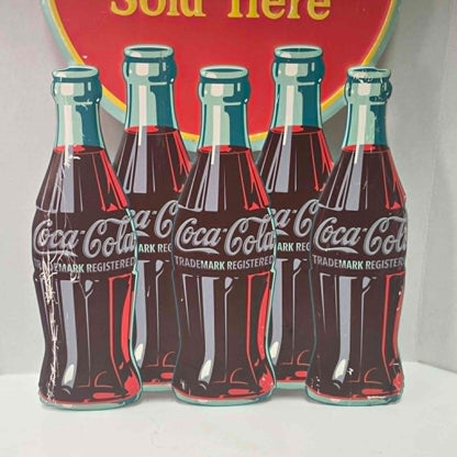 Large vintage Coca-Cola embossed metal sign with five bottles and advertising design.
