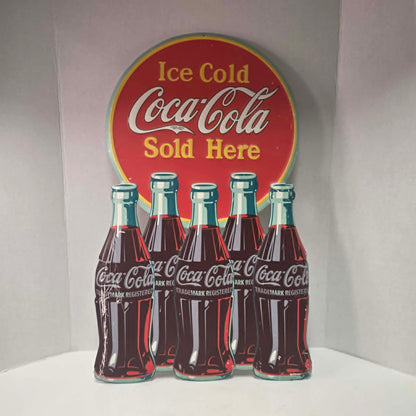 Large vintage Coca-Cola embossed metal sign with five bottles and advertising design.
