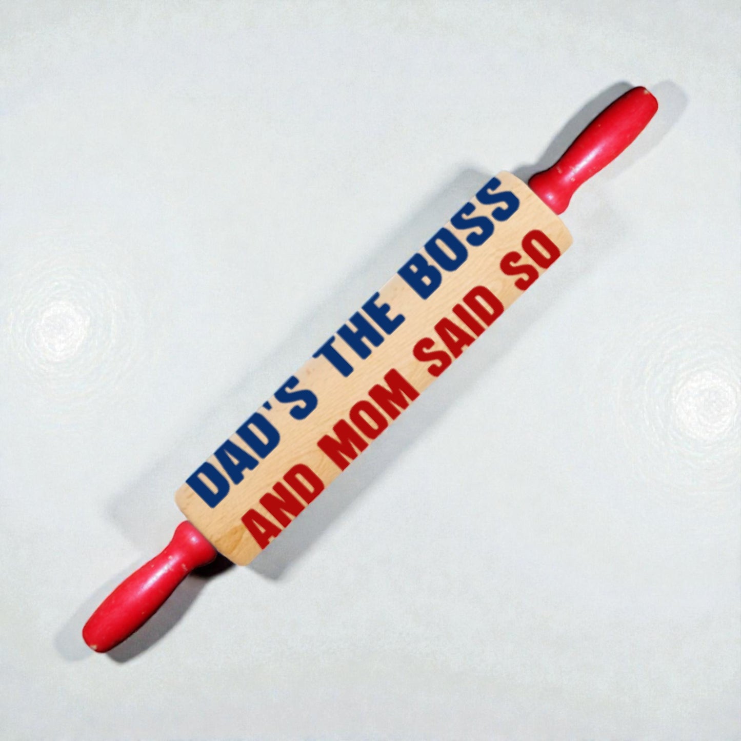 Rolling pin with text 'DAD'S THE BOSS AND MOM SAID SO' on a white background