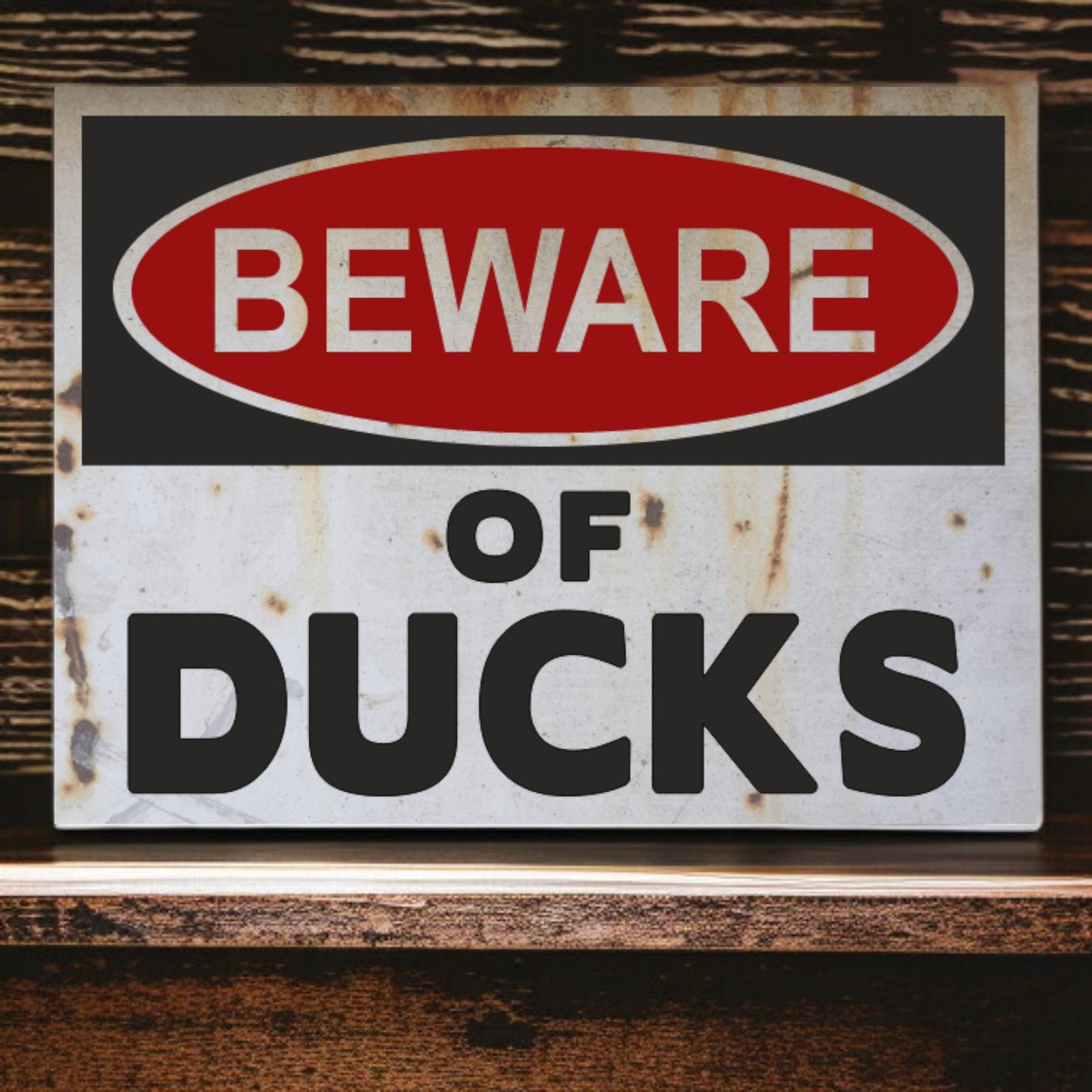 Vintage-style 'Beware of Ducks' sign with rust and wear on a wooden surface.