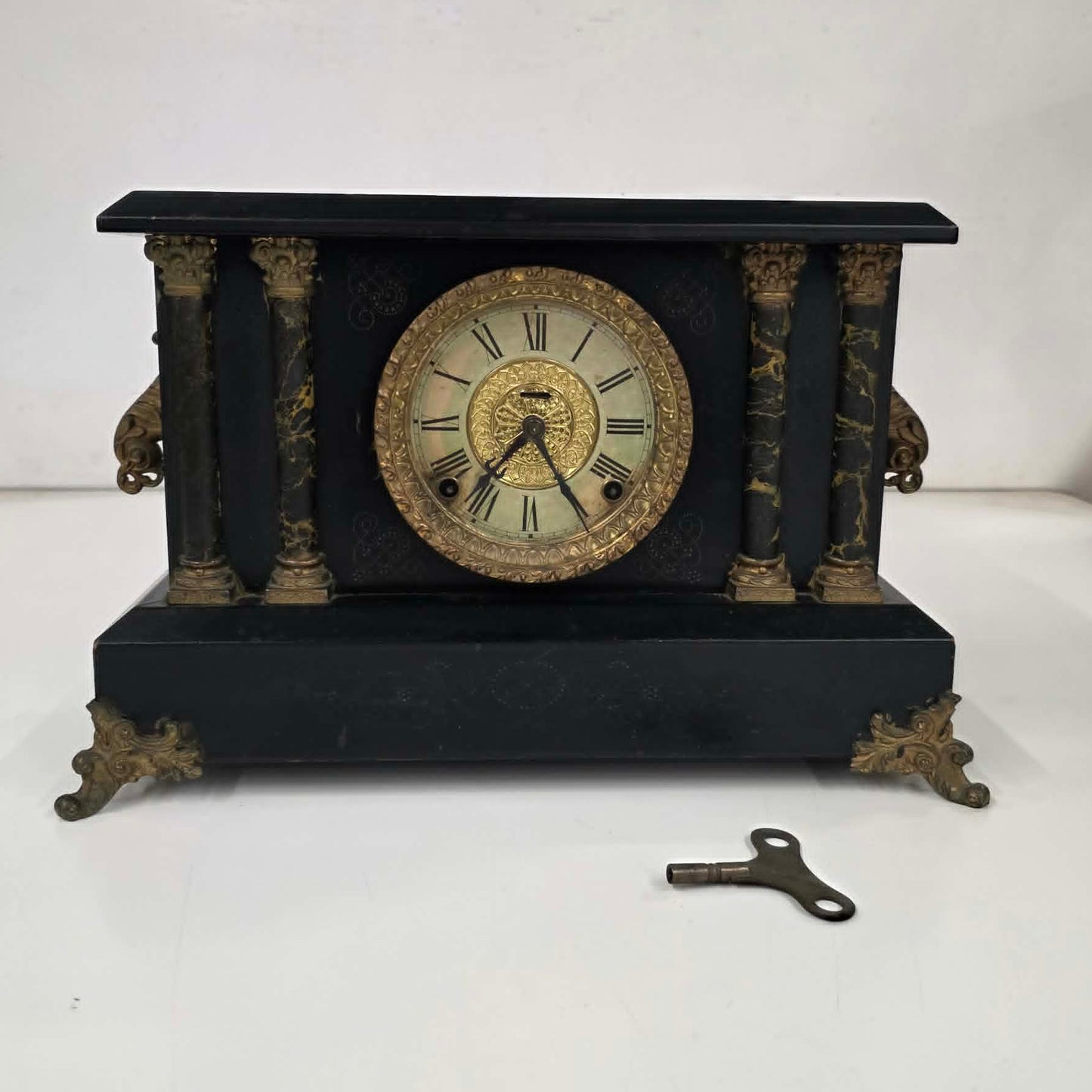 Antique E. Ingraham mantel clock with marbleized columns and bell strike movement.
