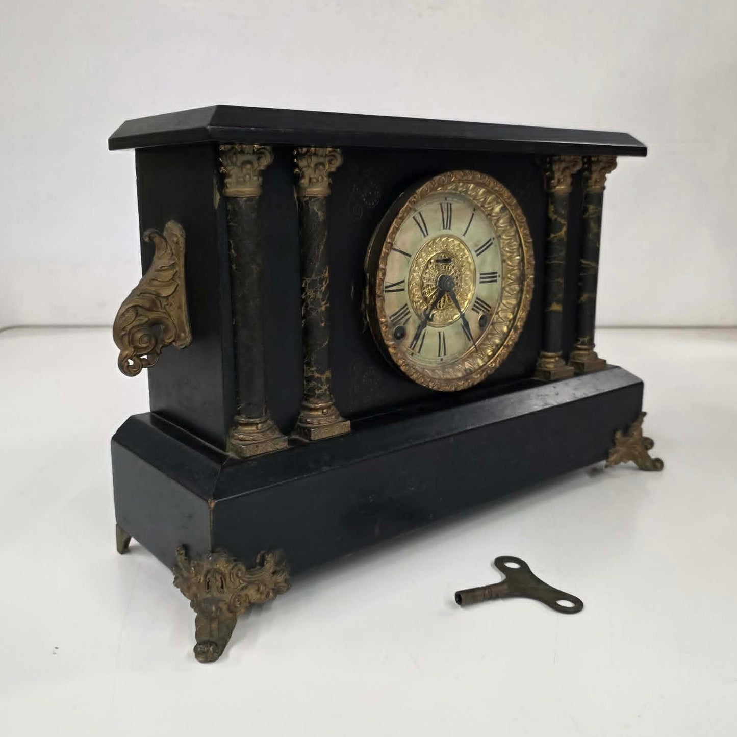 Antique E. Ingraham mantel clock with marbleized columns and bell strike movement.
