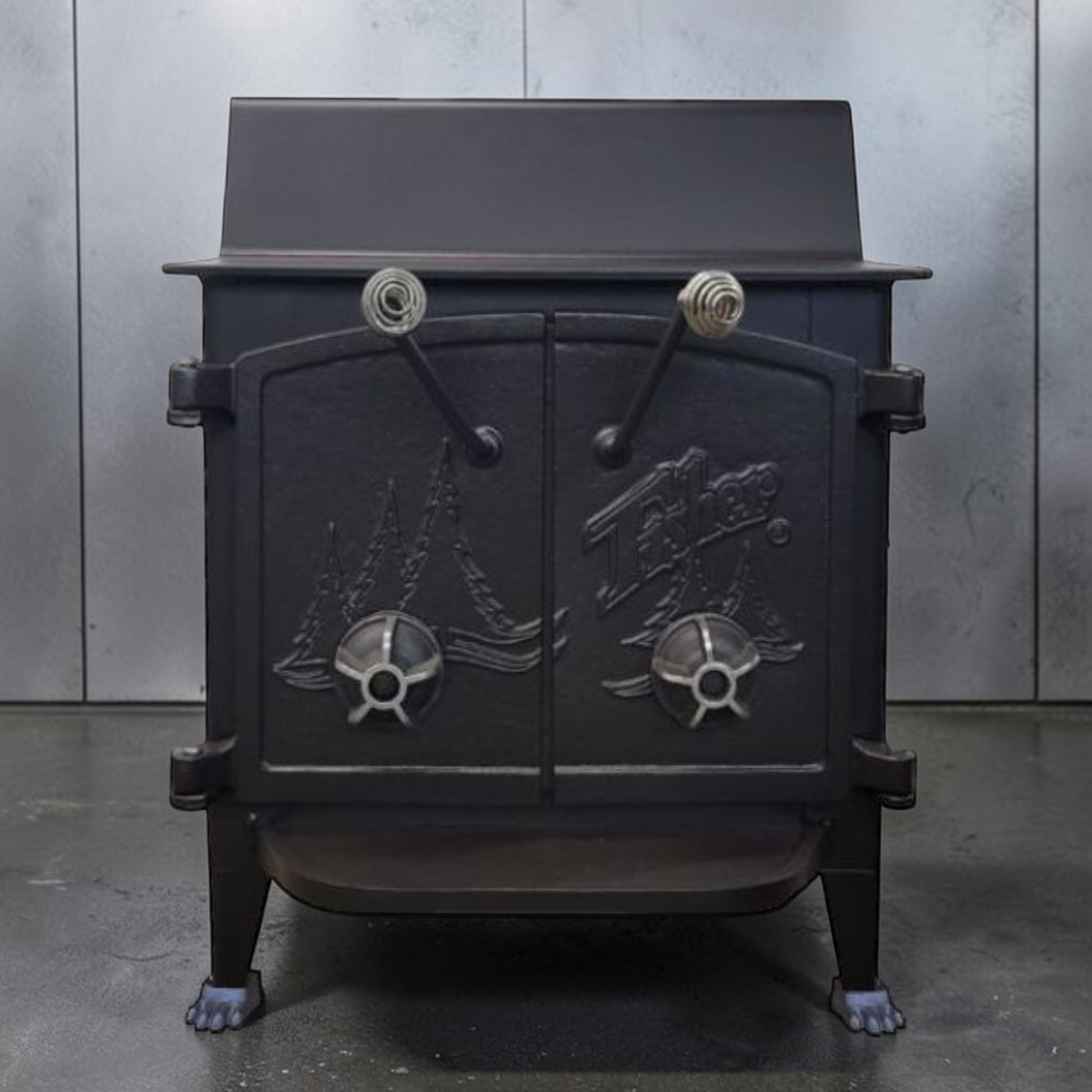 Fisher Grandma Bear wood stove with cathedral style doors and rear vent chimney cooking surface.
