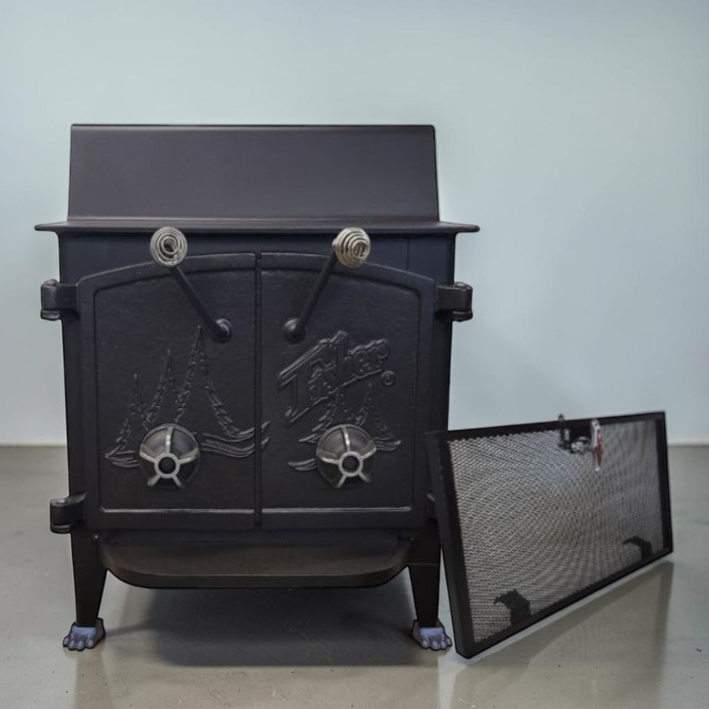 Fisher Grandma Bear wood stove with cathedral style doors and rear vent chimney cooking surface.
