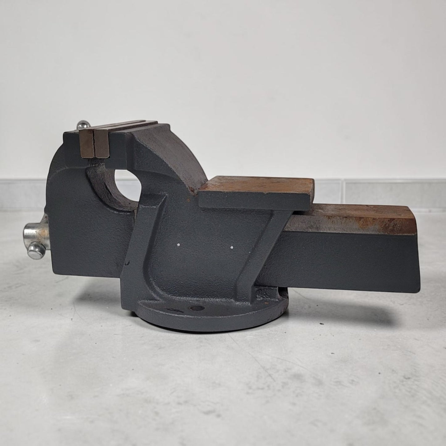 Vintage heavy duty cast iron bench vise with 5-inch jaws and rear anvil.

