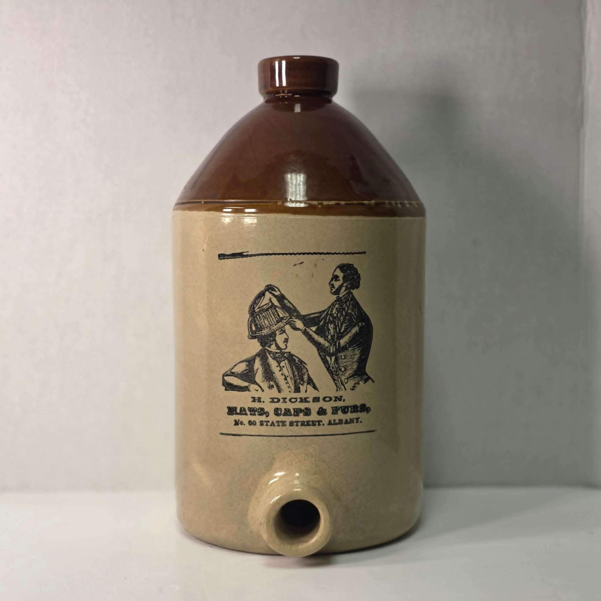 Antique H. Dickson Albany merchant crock with hat shop advertising graphic.
