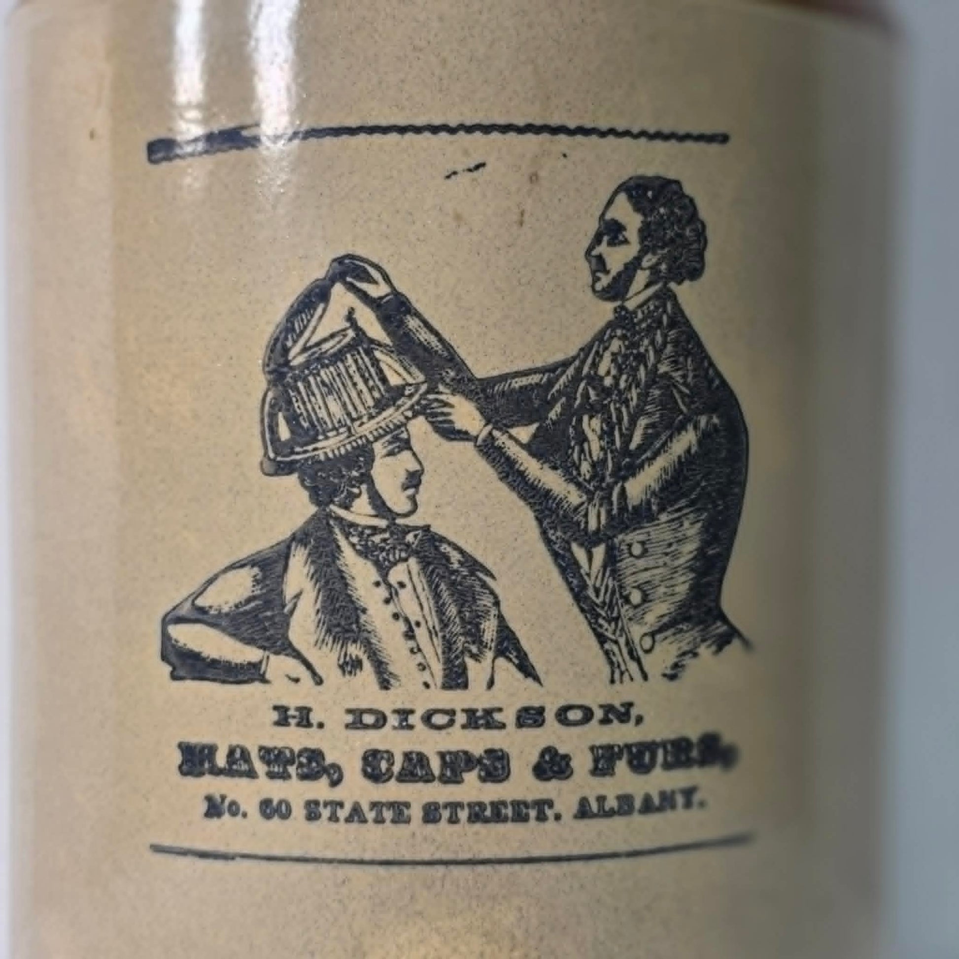 Antique H. Dickson Albany merchant crock with hat shop advertising graphic.