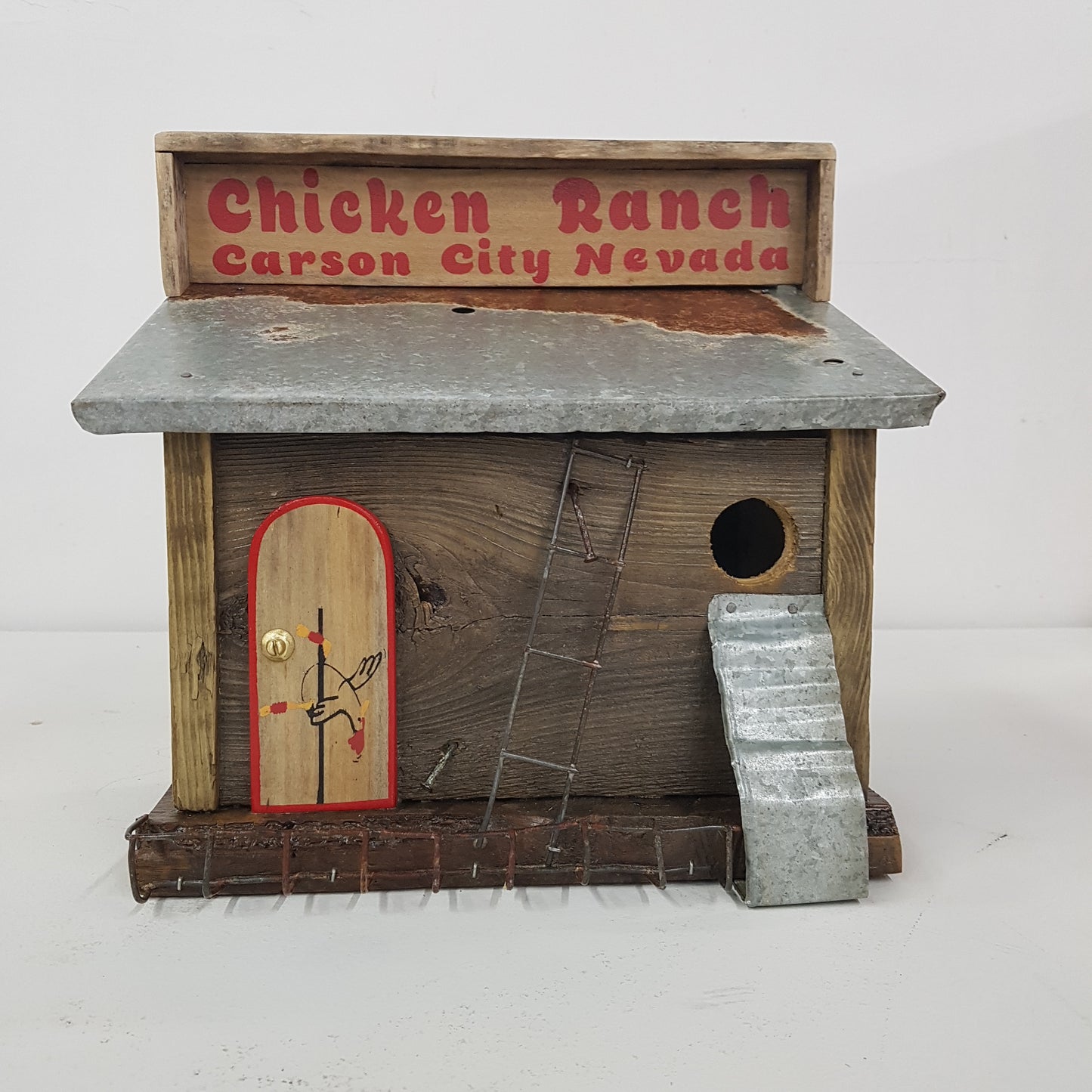 Handmade rustic Chicken Ranch folk art birdhouse made from reclaimed materials with chicken-themed artwork.
