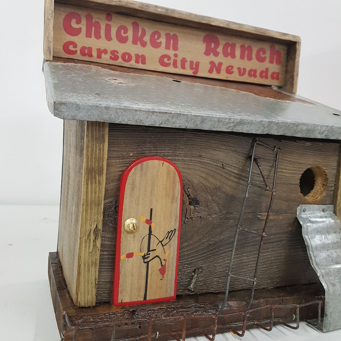 Handmade rustic Chicken Ranch folk art birdhouse made from reclaimed materials with chicken-themed artwork.
