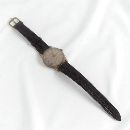 Vintage wristwatch with a brown leather strap on a white background