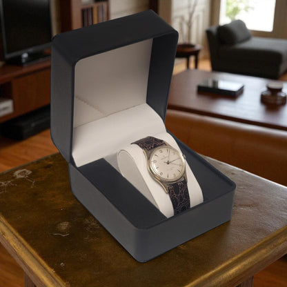 Watch in a gray box on a wooden table with a blurred background