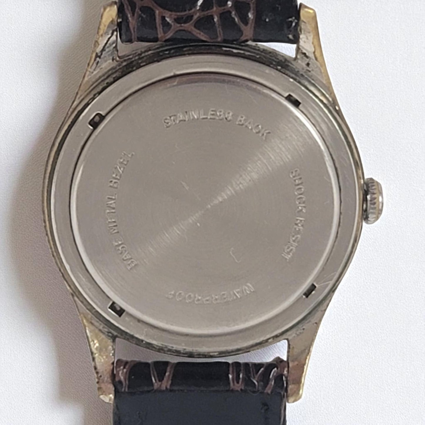 Back view of a watch with 'Stainless Back' engraving on a white background