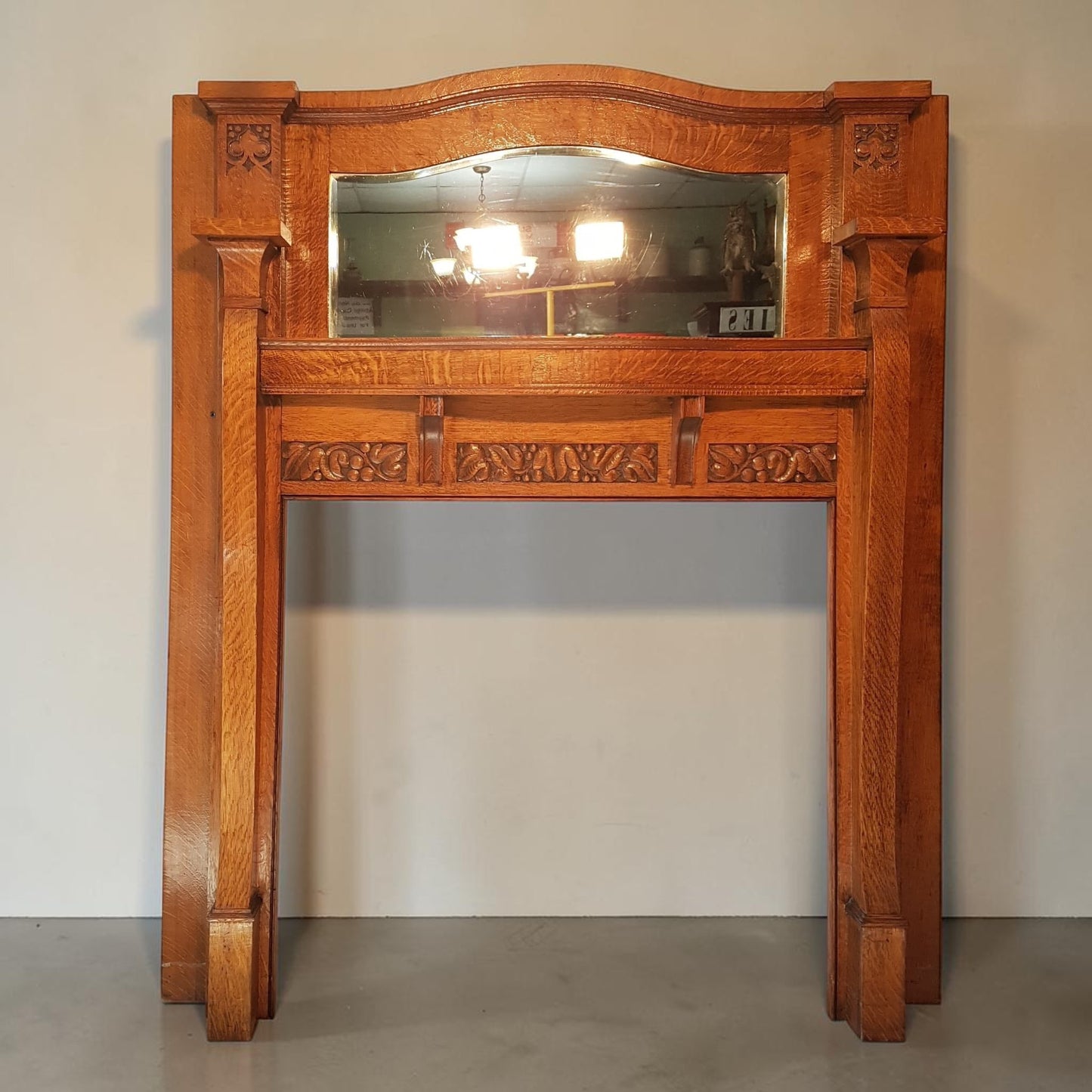 Historic Arts & Crafts oak fireplace mantle with original beveled mirror.