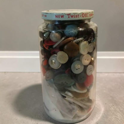 Jar full of assorted antique vintage buttons for crafting and sewing projects.
