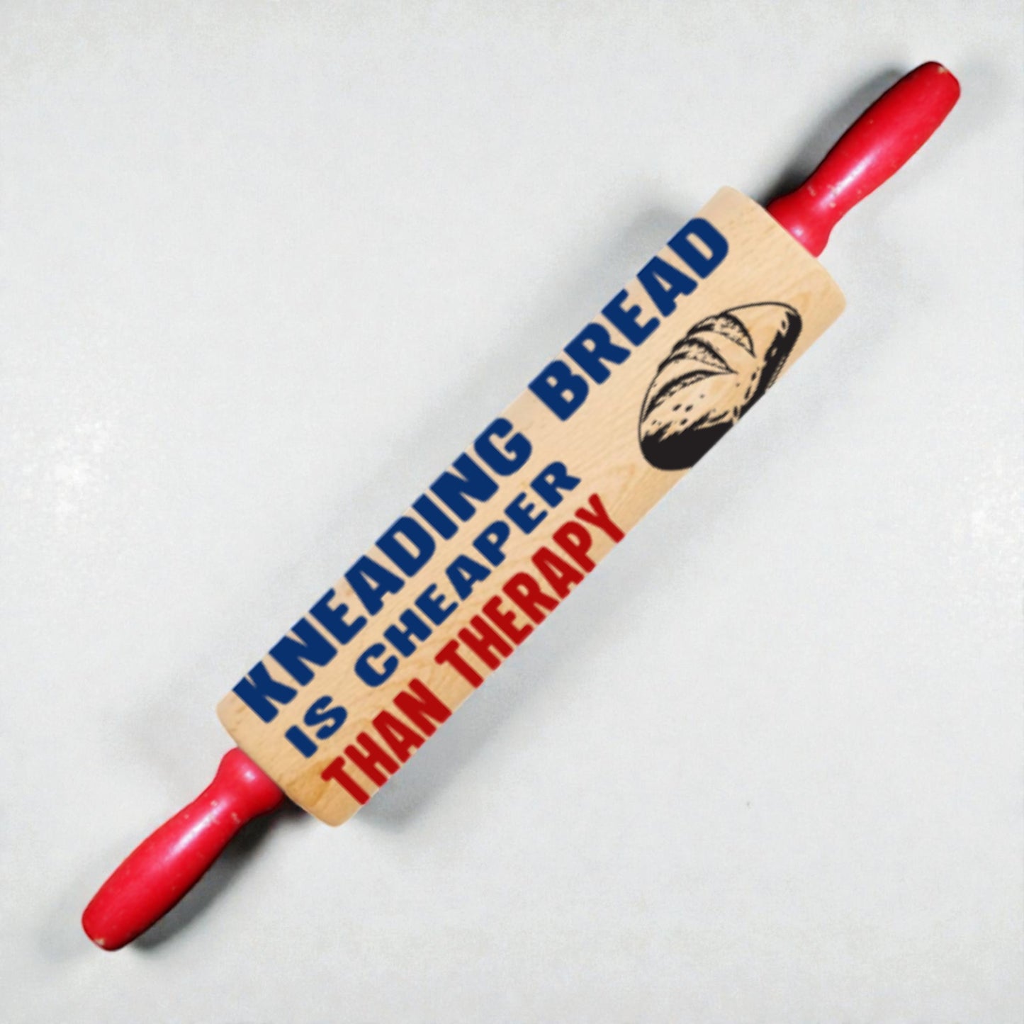 Red rolling pin with a wooden paddle featuring text and a bread illustration on a light gray background