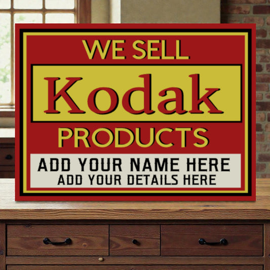 Vintage-style sign advertising Kodak products on a wooden surface.