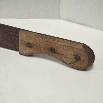 Large antique wooden handled machete with curved ridged blade.
