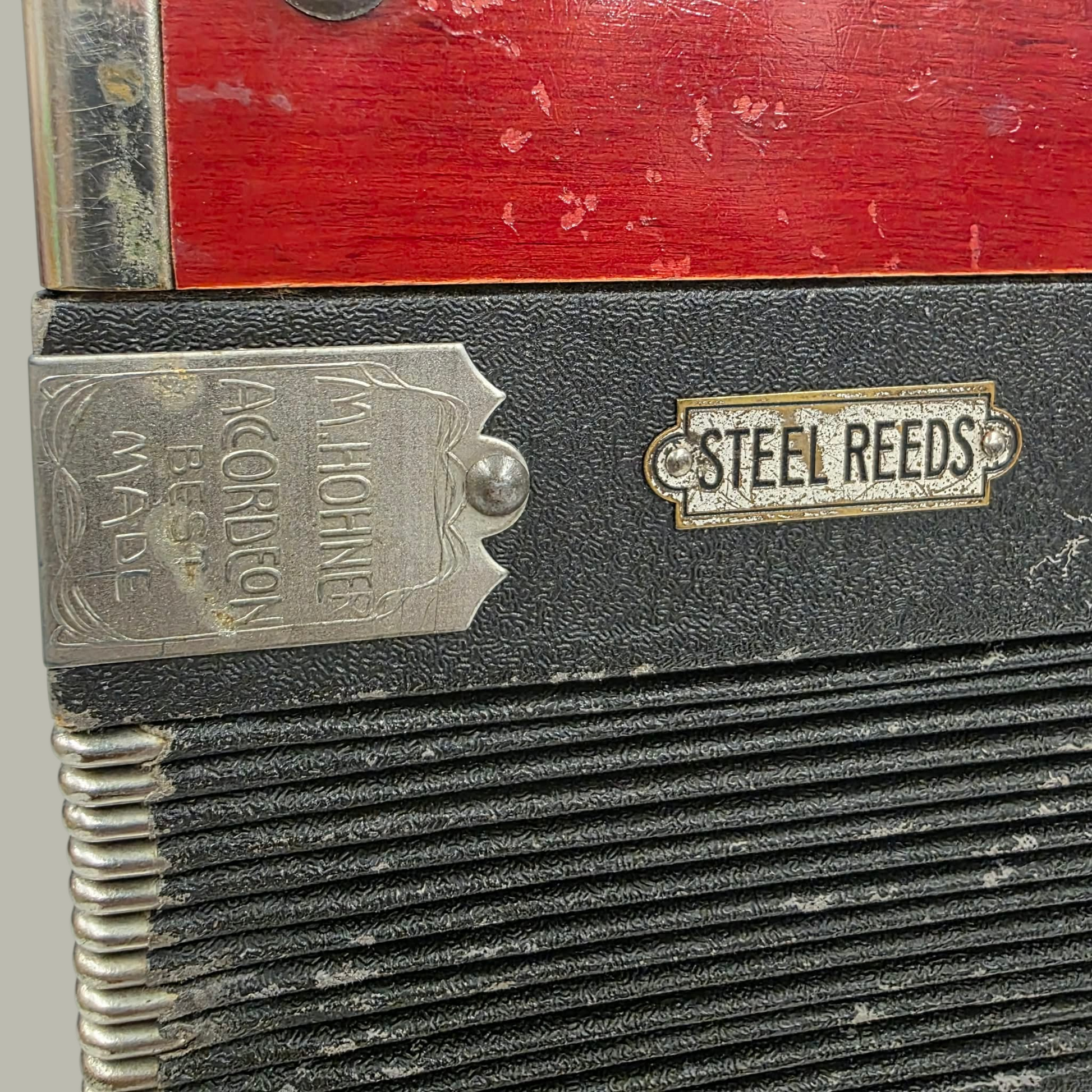 Close-up of an accordion with 'Steel Reeds' branding on a gray background