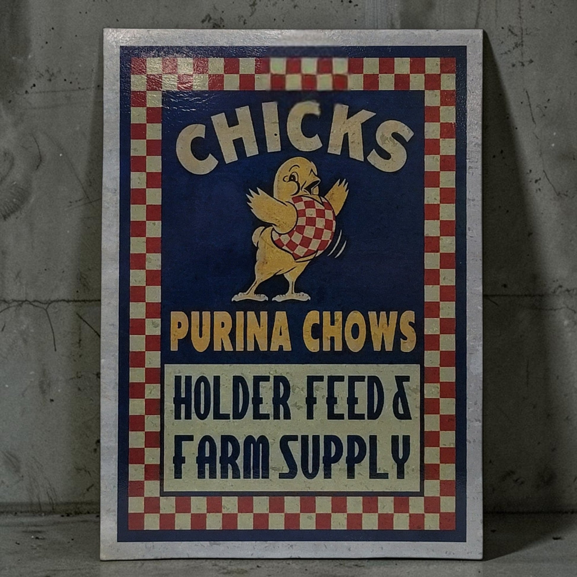 Vintage-style sign for Purina Chows with a chicken illustration on a textured wall.